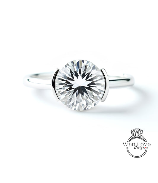 A close-up of a silver ring with a large, round diamond set in the center.