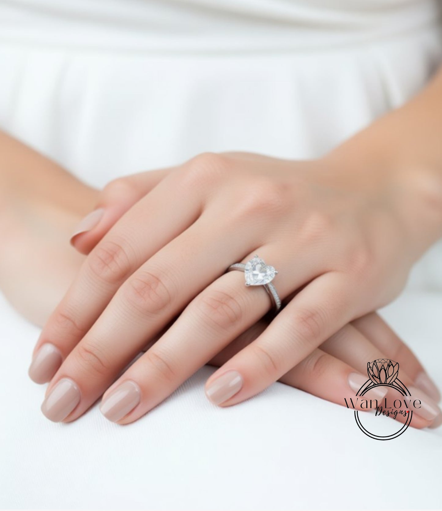 A close-up of a person's hands wearing a diamond engagement ring.