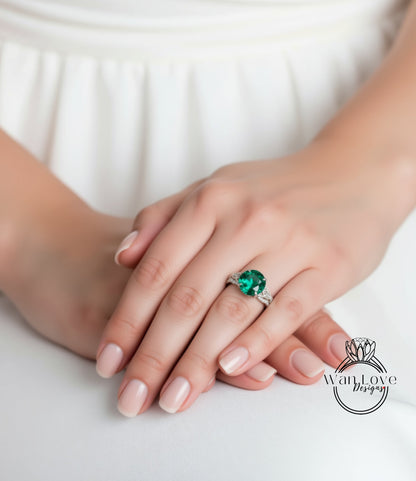 A close-up of a person's hands wearing a ring with a large green gemstone.
