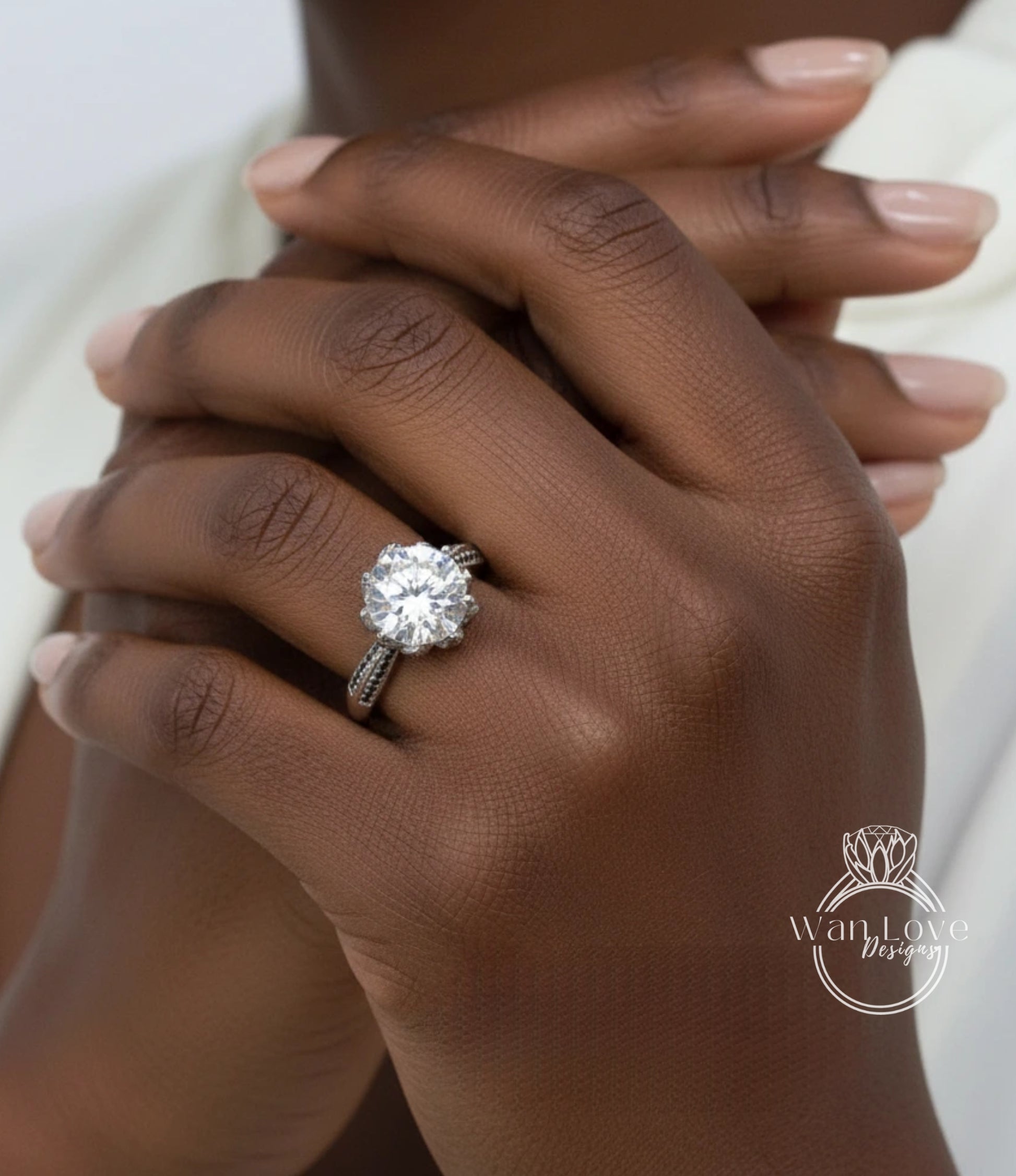 A close-up of a person's hand wearing a large diamond engagement ring.