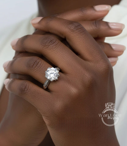 A close-up of a person's hand wearing a large diamond engagement ring.