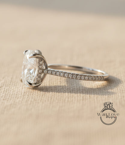 A close-up view of a diamond engagement ring with a large central diamond and smaller diamonds around the sides, resting on a textured surface.