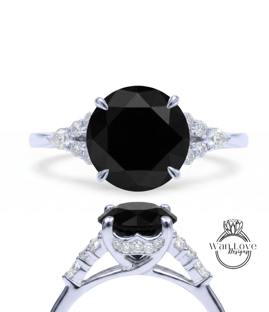 A silver ring with a large black diamond as the centerpiece, surrounded by smaller diamonds.