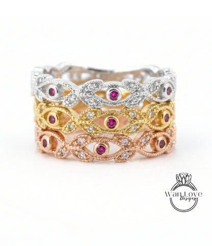 A ring with three distinct layers, each featuring a unique design and color of gemstones. The topmost layer is silver, the middle layer is gold, and the bottom layer is pink. The ring is adorned with small gemstones, adding to its elegance and charm.