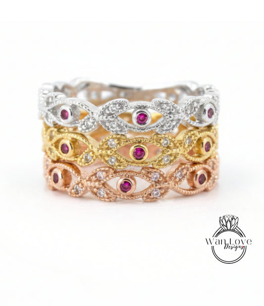 A ring with three distinct layers, each featuring a unique design and color of gemstones. The topmost layer is silver, the middle layer is gold, and the bottom layer is pink. The ring is adorned with small gemstones, adding to its elegance and charm.