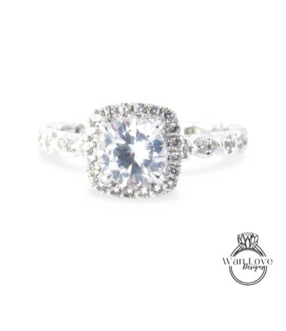 A close-up view of a diamond engagement ring with a large, brilliant-cut diamond at the center, surrounded by smaller diamonds and set in a halo of smaller diamonds.