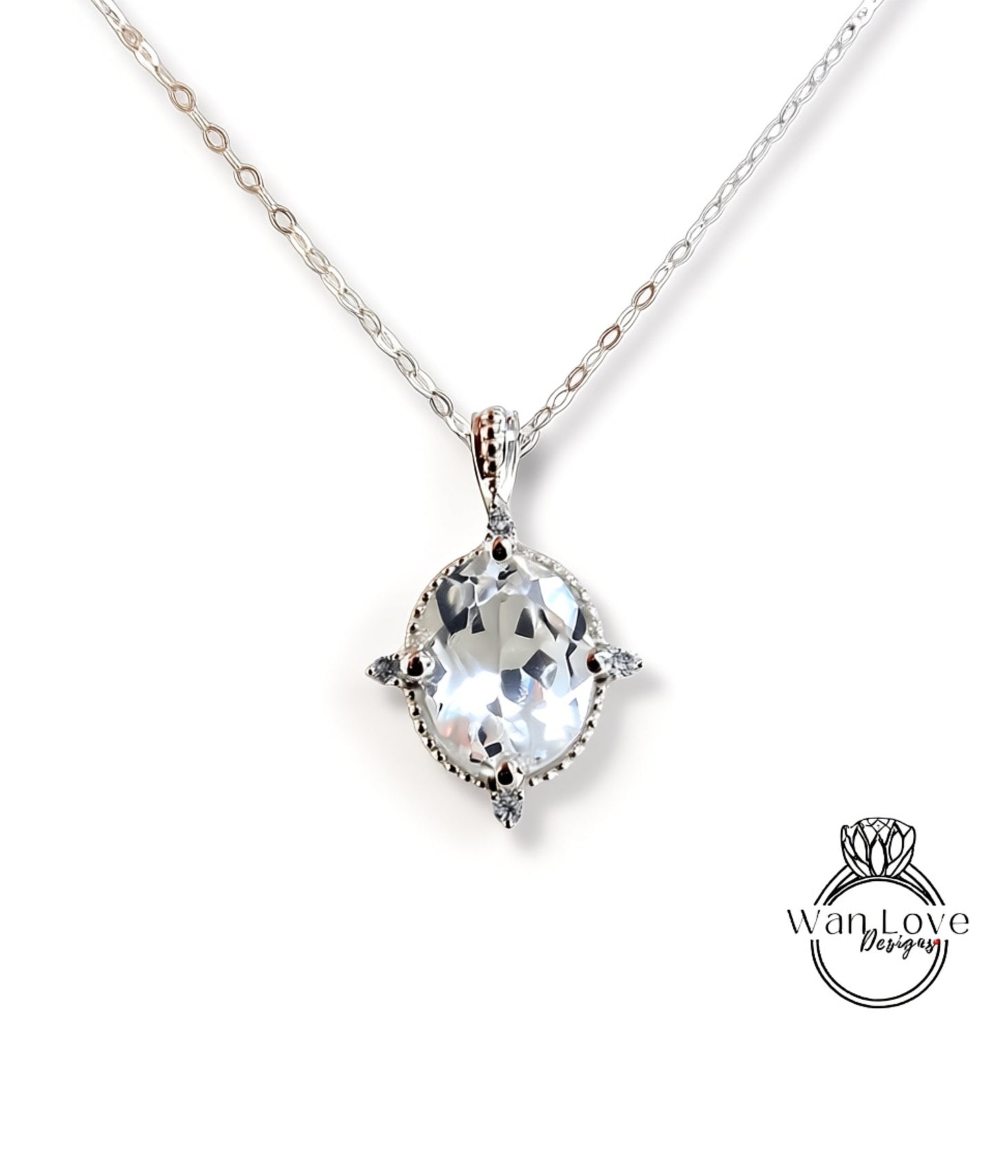 A silver necklace with a large, clear gemstone pendant.