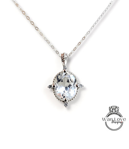 A silver necklace with a large, clear gemstone pendant.