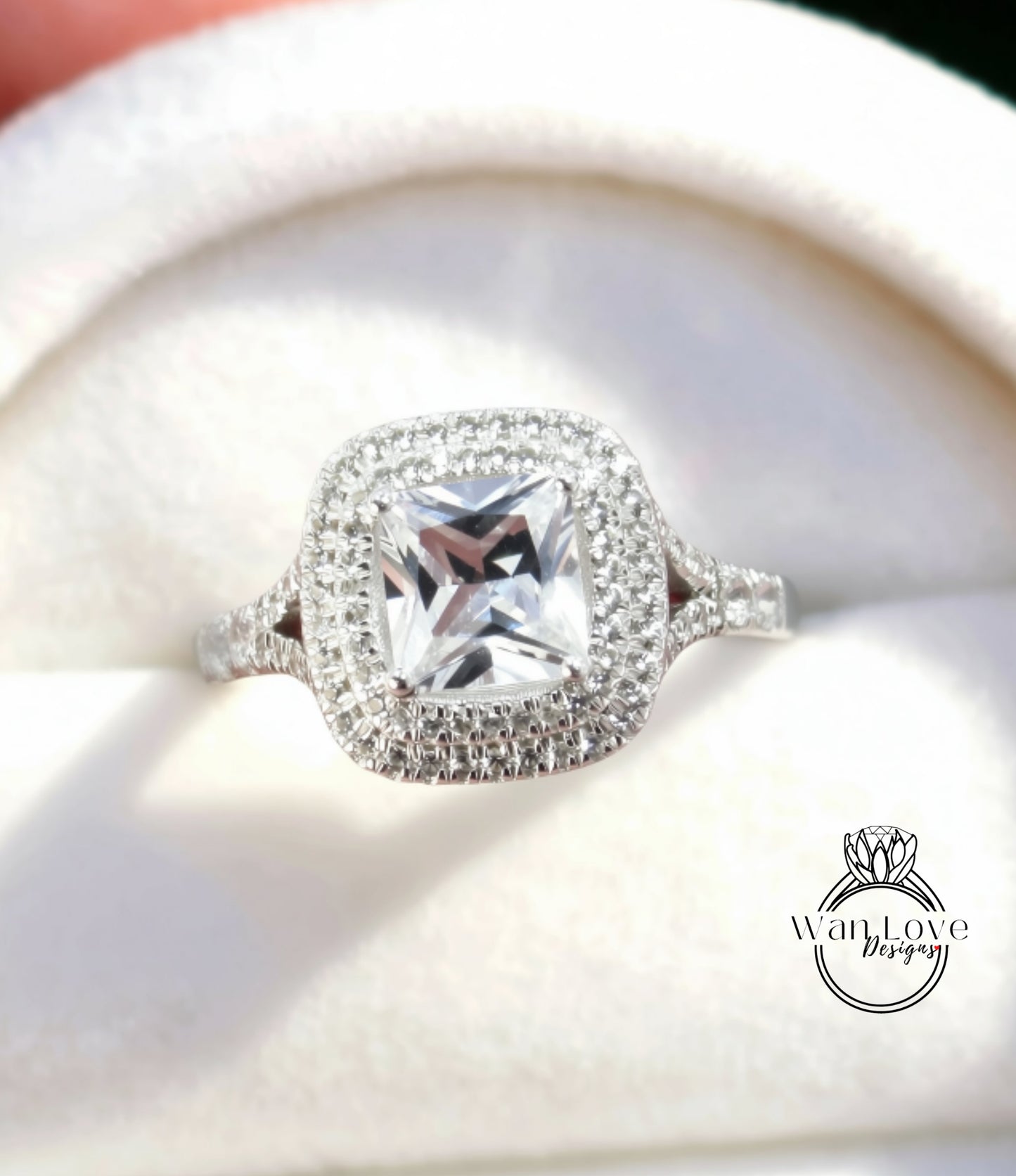 A close-up view of a diamond engagement ring with a large, clear gemstone set in a halo of smaller diamonds.