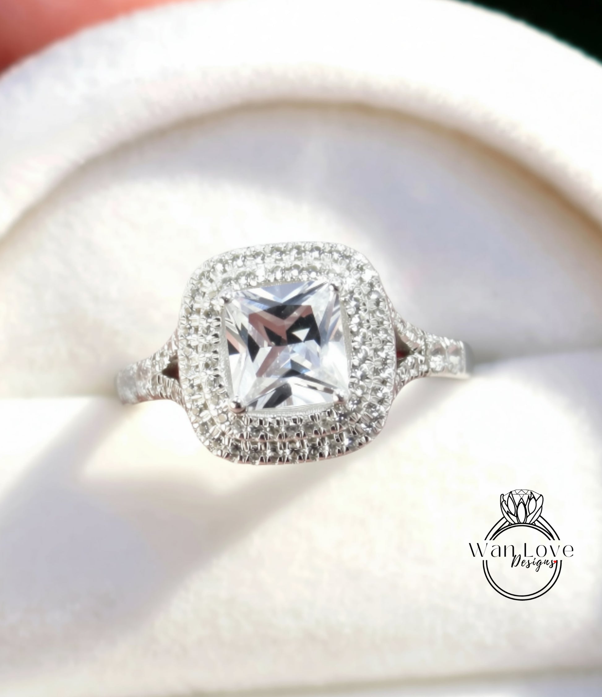 A close-up view of a diamond engagement ring with a large, clear gemstone set in a halo of smaller diamonds.