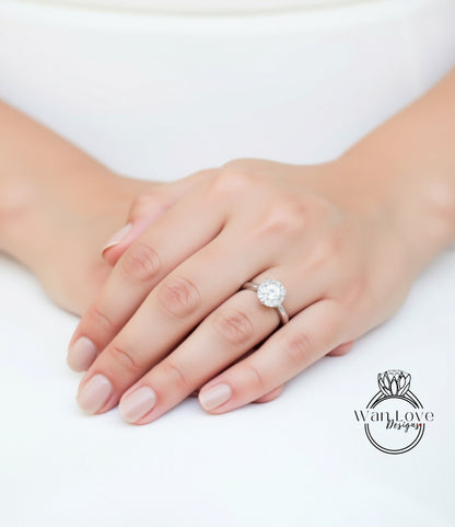 A close-up of a person's hand wearing a diamond engagement ring.