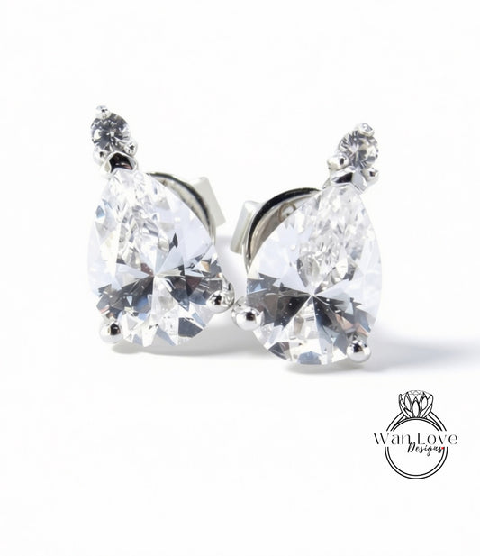 A pair of elegant earrings with large, clear gemstones set in a silver metal frame.