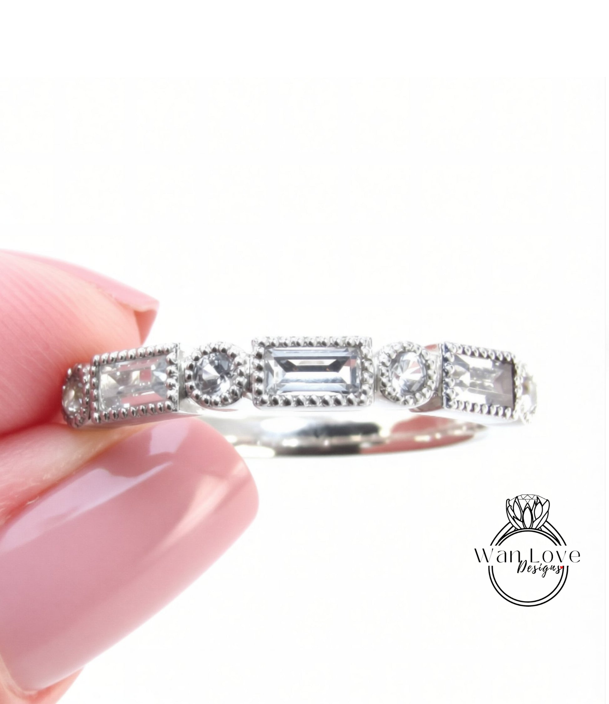 A close-up image of a person's hand holding a silver ring adorned with various gemstones.