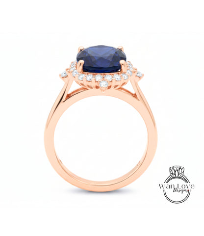 A rose gold ring with a large blue gemstone set in the center, surrounded by smaller diamonds.
