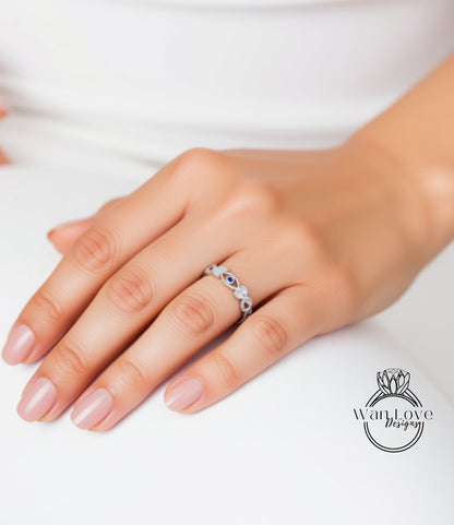 A close-up of a hand wearing a silver ring with blue stones.