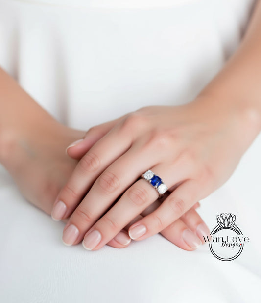 A close-up image of a person's hands wearing a ring with a blue gemstone.