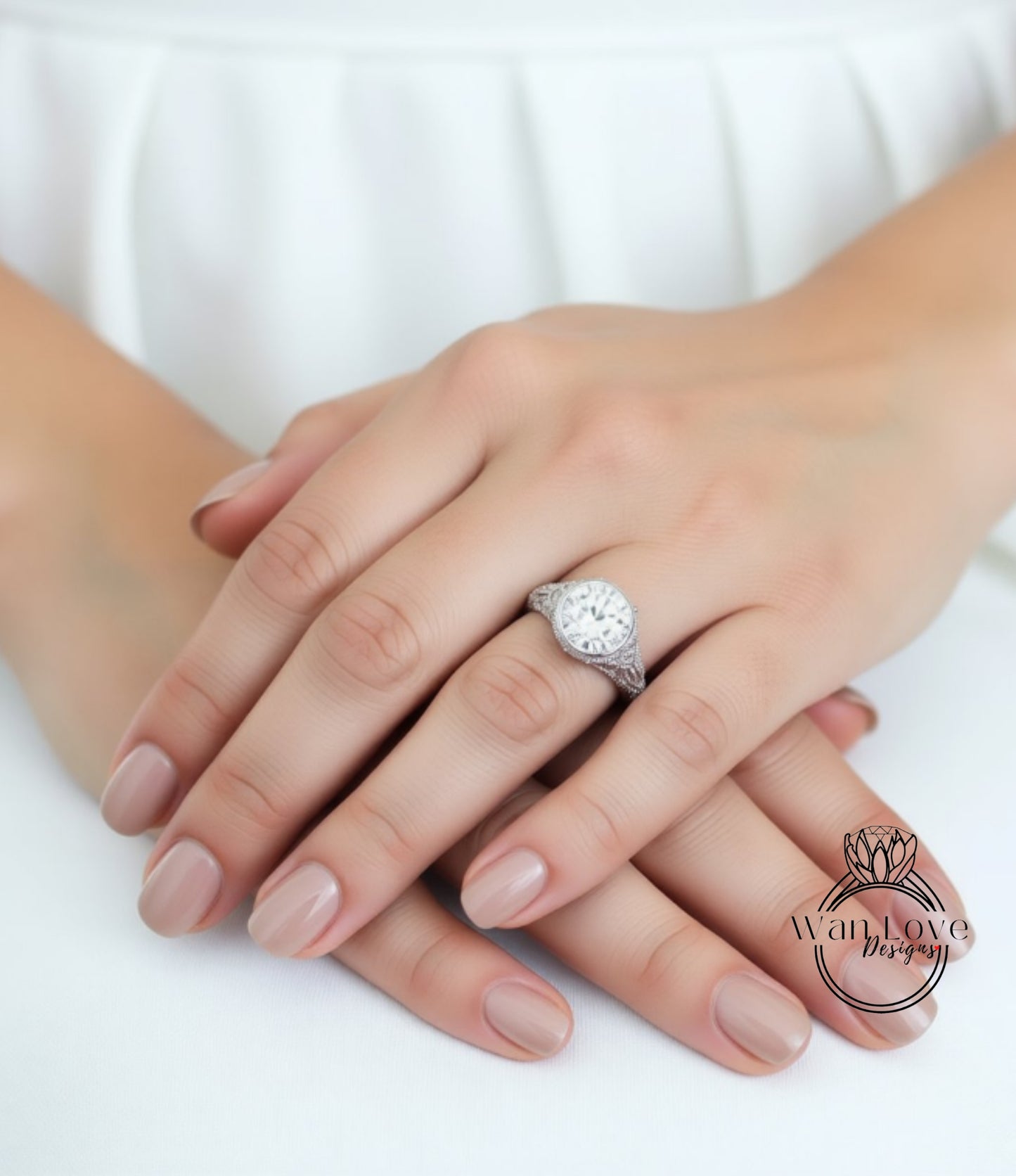 A close-up image of a person's hands with a large, ornate ring on the ring finger.