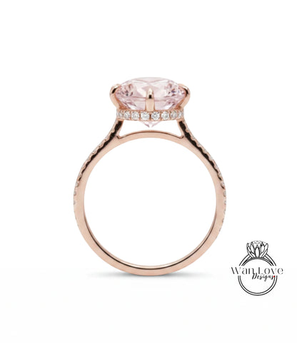 A rose gold engagement ring with a large pink gemstone set in the center, surrounded by a halo of smaller diamonds.