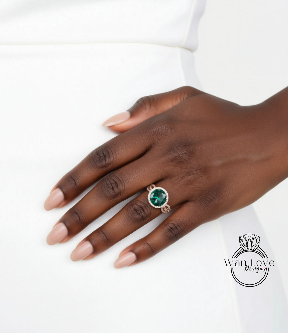 A close-up of a hand wearing a ring with a green gemstone.