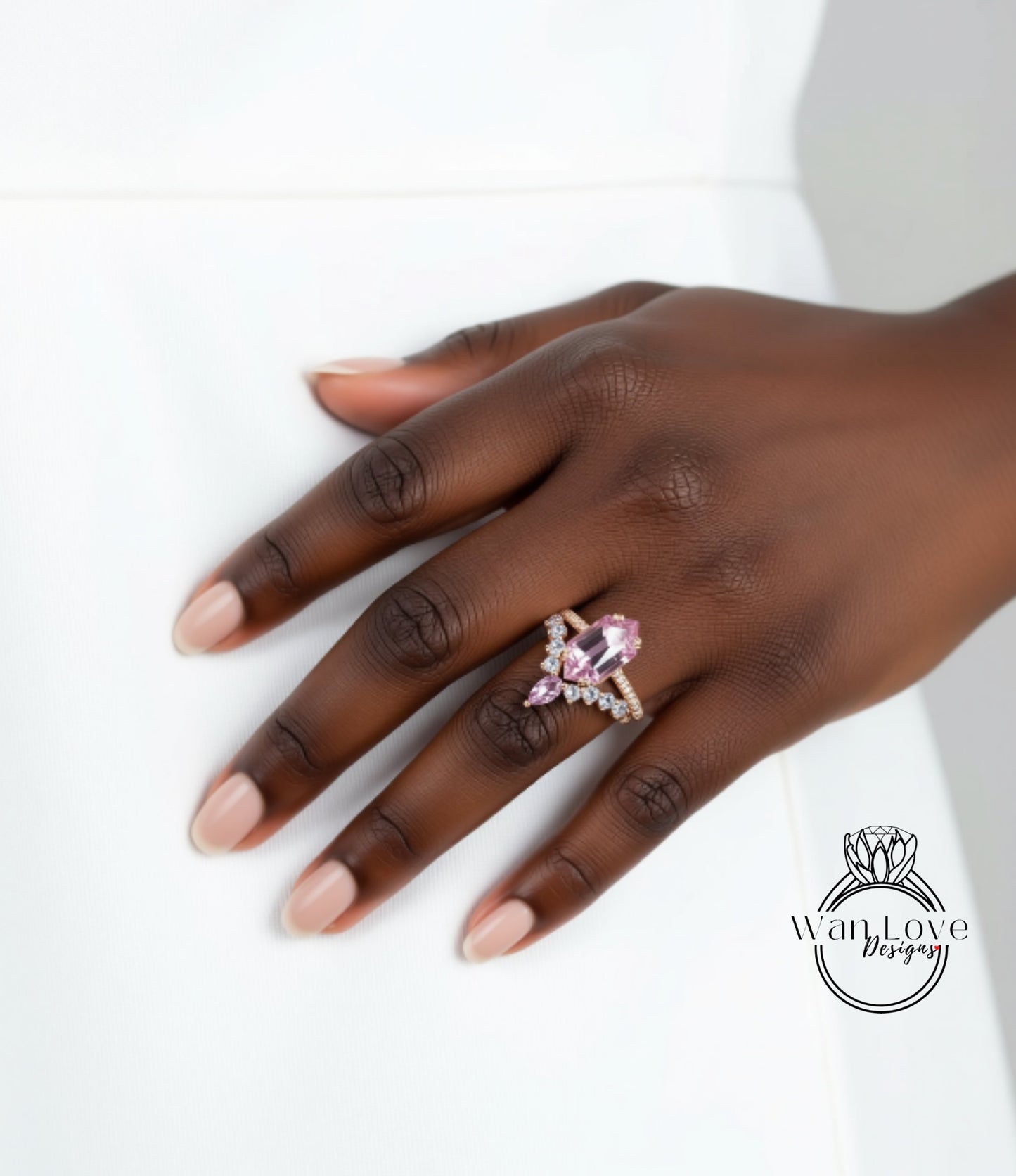 A close-up of a hand wearing a ring with a large pink gemstone.