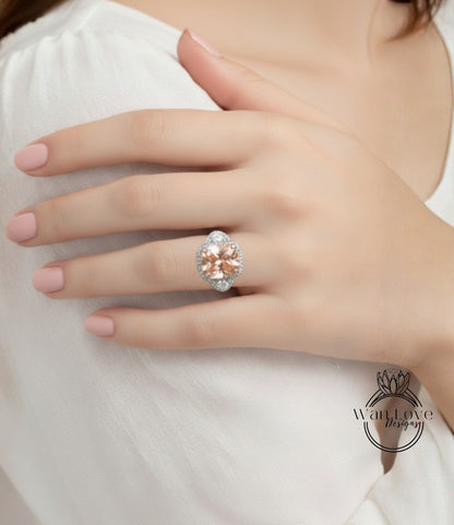 A close-up of a person's hand wearing a large, ornate ring with a large, round, peach-colored gemstone.