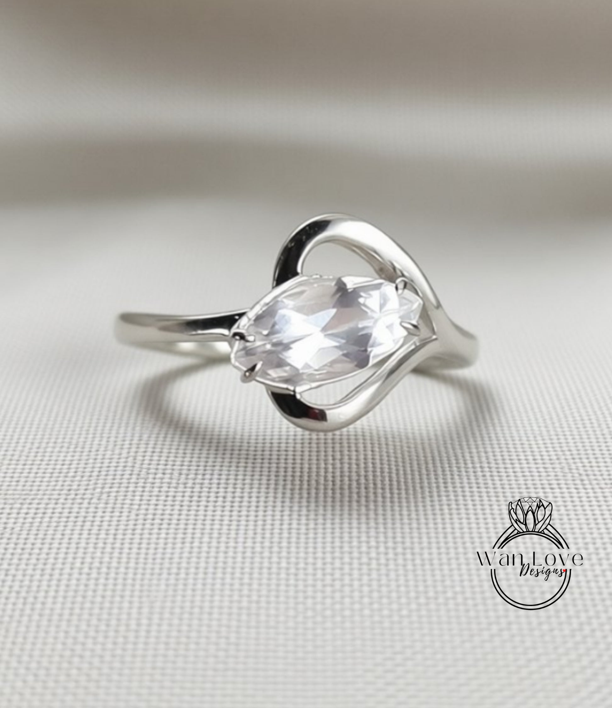 A silver ring with a large, clear gemstone set in a heart-shaped design.