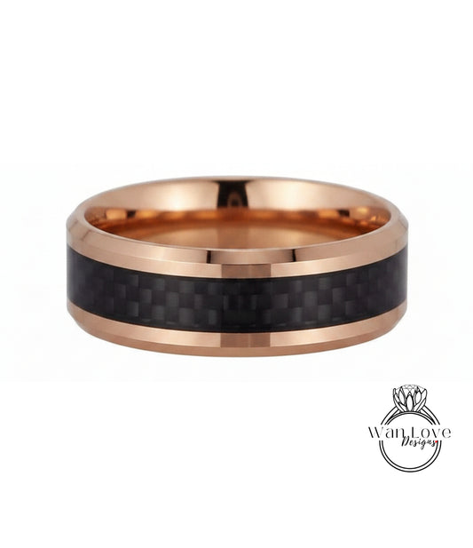 A gold-toned ring with a black carbon fiber band, showcasing a unique and stylish design.