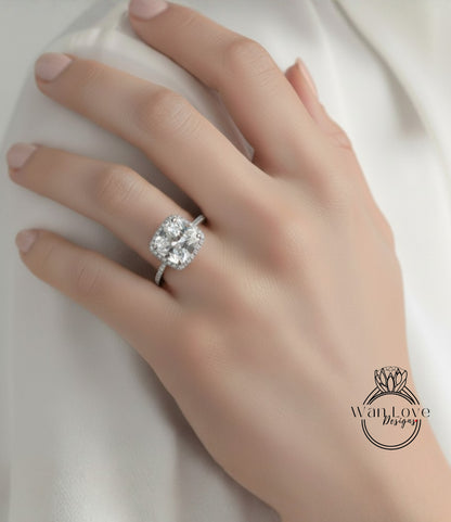 A close-up of a hand wearing a large diamond engagement ring.