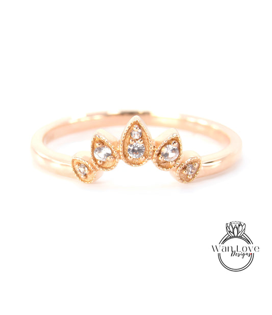 A gold ring with a decorative band featuring a central stone design surrounded by smaller stones.