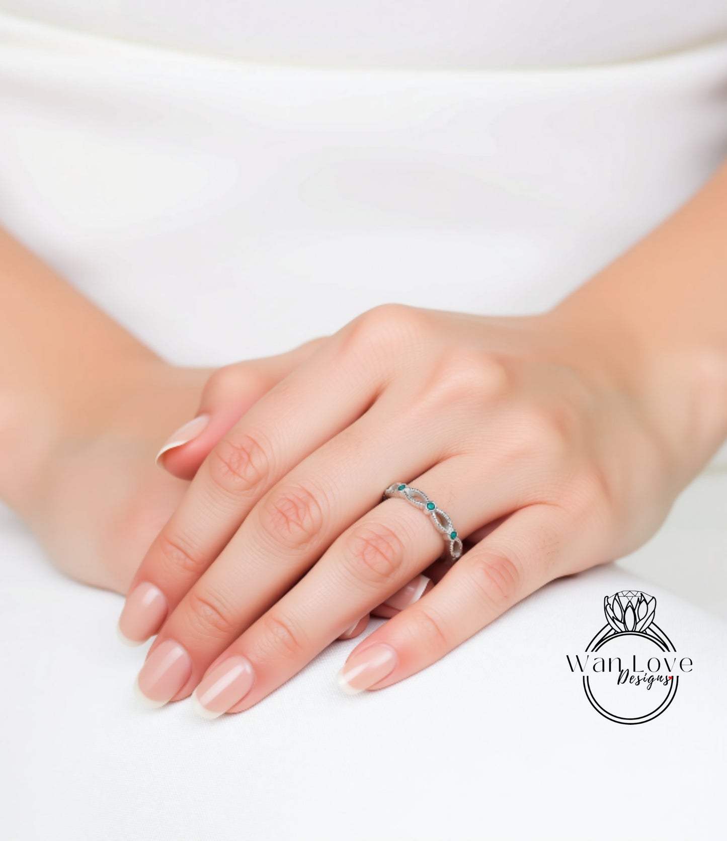 A close-up of a person's hand wearing a ring with blue stones.