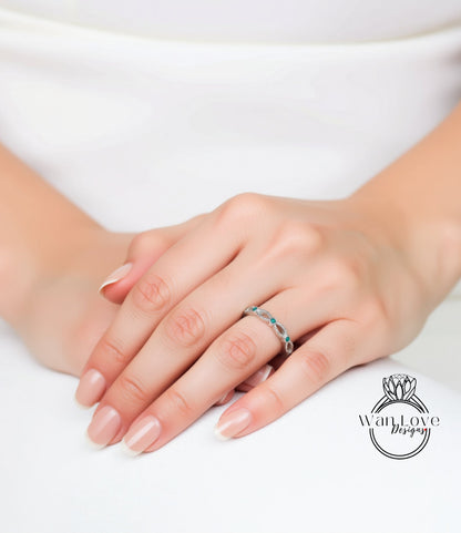 A close-up of a person's hand wearing a ring with blue stones.