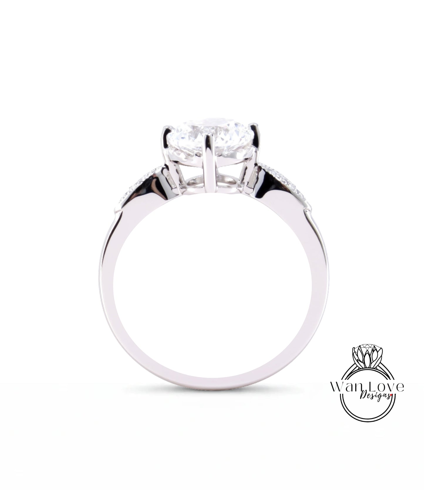 A close-up view of a silver engagement ring with a large central diamond and smaller diamonds on either side.