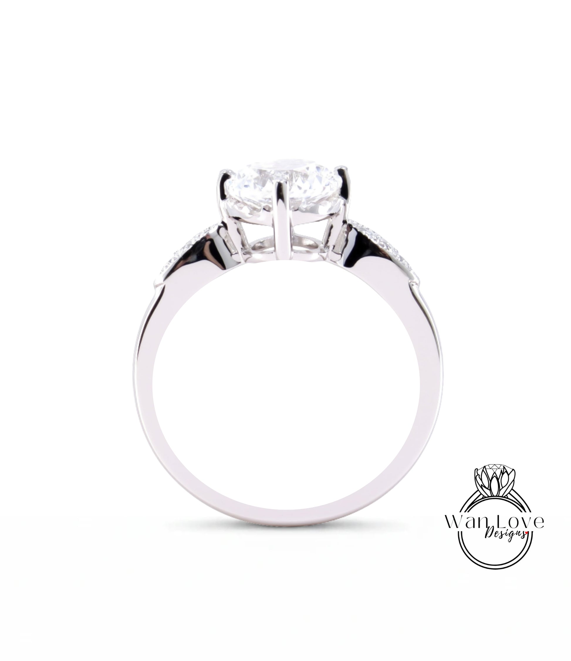 A close-up view of a silver engagement ring with a large central diamond and smaller diamonds on either side.
