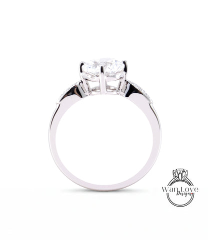 A close-up view of a silver engagement ring with a large central diamond and smaller diamonds on either side.