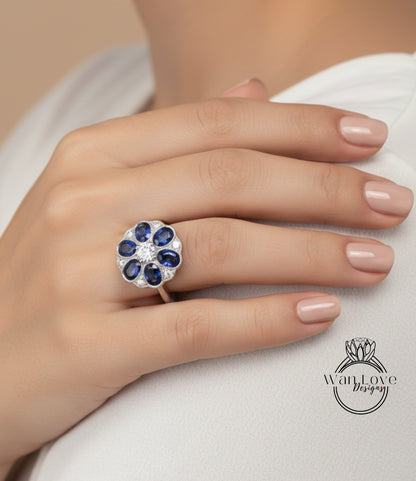 A close-up of a hand wearing a ring with a large blue gemstone set in a silver band.
