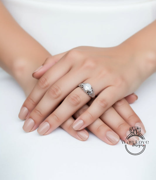 A close-up image of a person's hands with a ring on the finger, resting on a white surface.