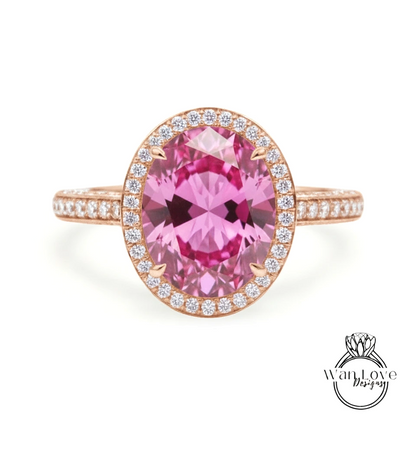A pink gemstone ring with a halo of smaller diamonds around the center stone.