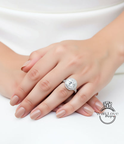 A close-up of a person's hand wearing a large, sparkling diamond ring.