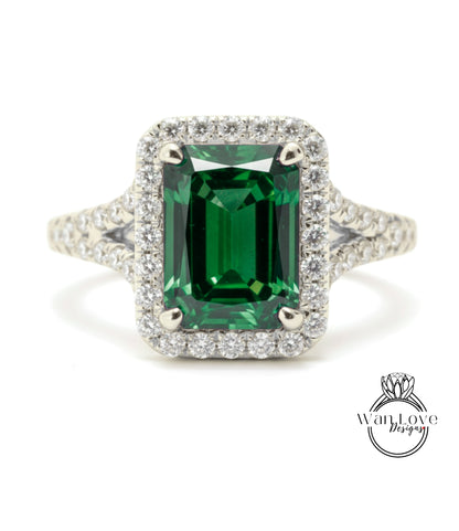 A stunning ring featuring a large, rectangular green gemstone surrounded by a halo of smaller diamonds set in a silver band.