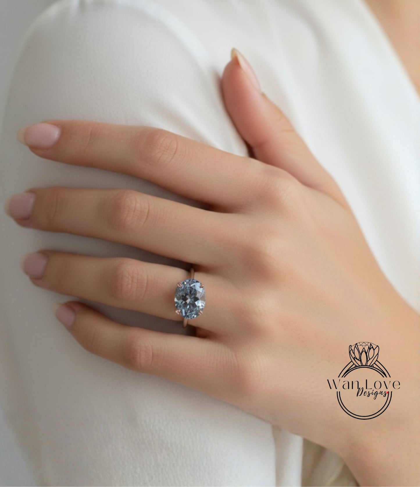 A close-up of a hand wearing a large, blue diamond engagement ring.