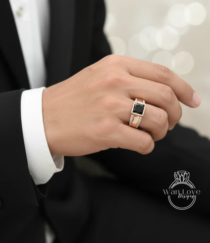 A close-up of a person's hand wearing a gold ring with a black gemstone.