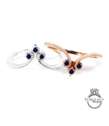 two rings with blue gemstones, one silver and one gold, set against a white background.