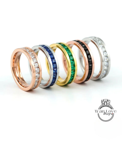 A row of six rings with various gemstones and designs, including diamonds, sapphires, and emeralds, displayed against a white background.