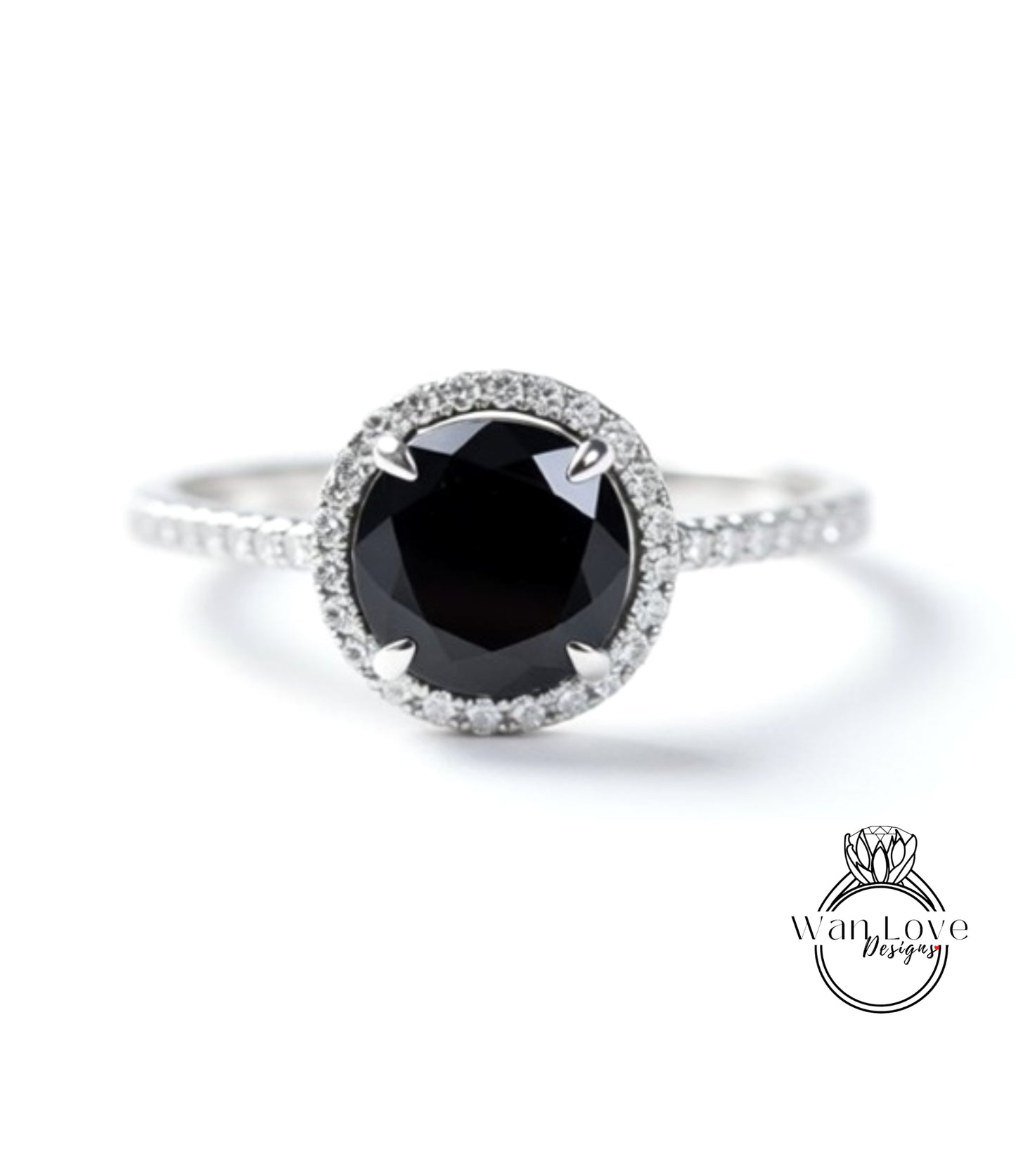 A close-up image of a silver ring with a large black diamond as the centerpiece, surrounded by smaller diamonds.