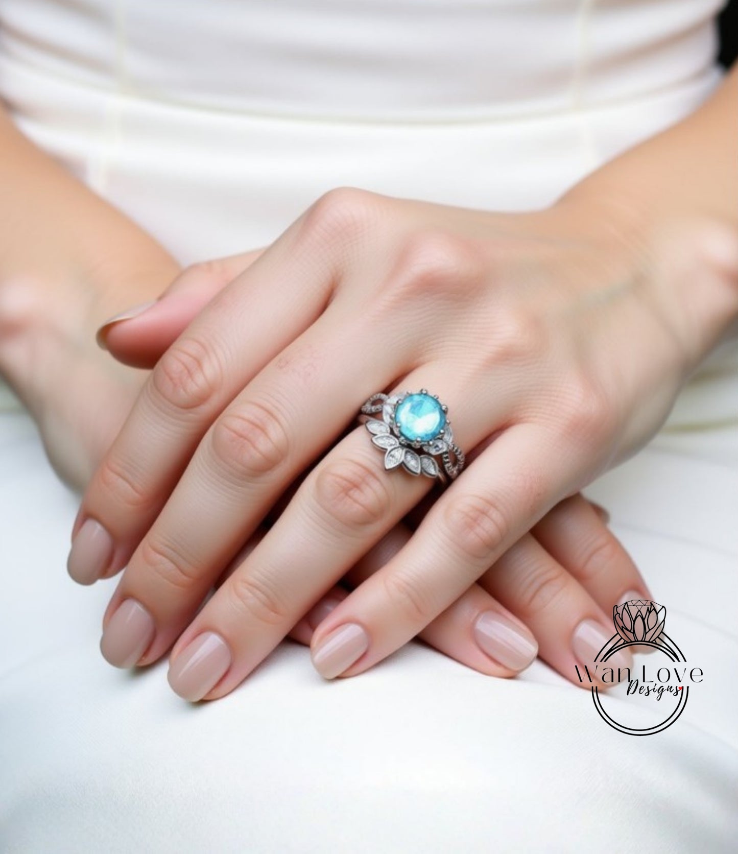 A close-up image of a person's hands wearing a ring with a blue gemstone.