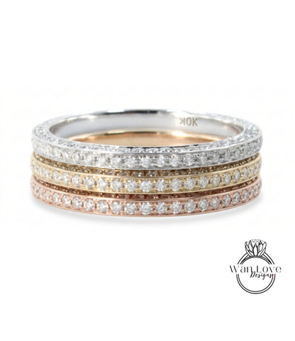 A ring with a band of diamonds in various colors, including silver, gold, and pink.