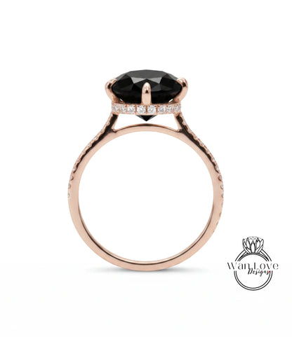 A rose gold engagement ring with a large black gemstone, such as a diamond, set in the center.