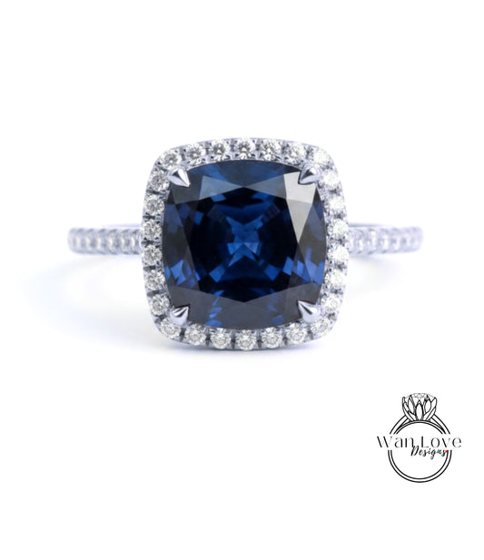 A stunning blue gemstone ring with a halo of diamonds around the center stone.