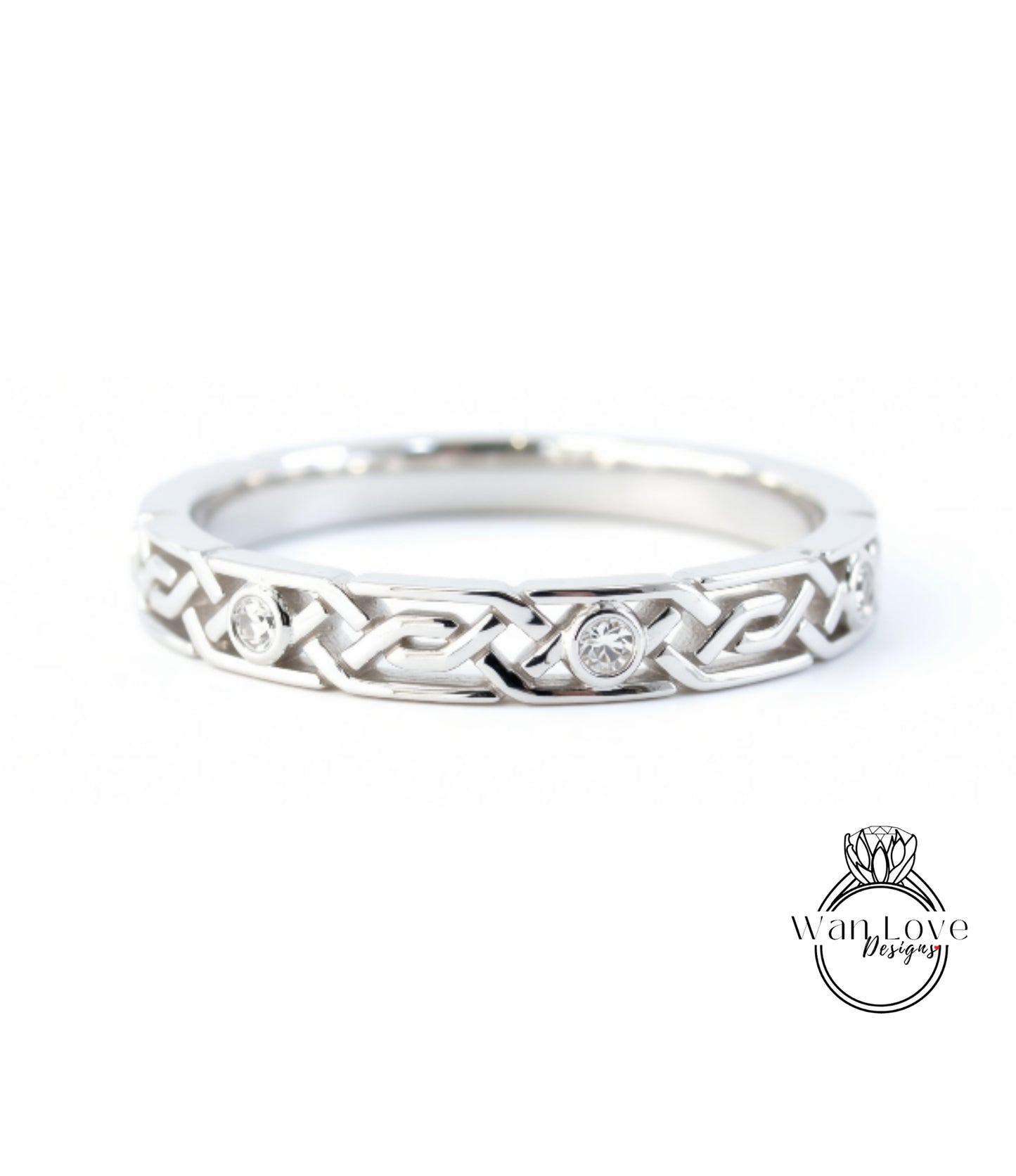 A silver ring with a Celtic knot design and two diamonds set in the center.