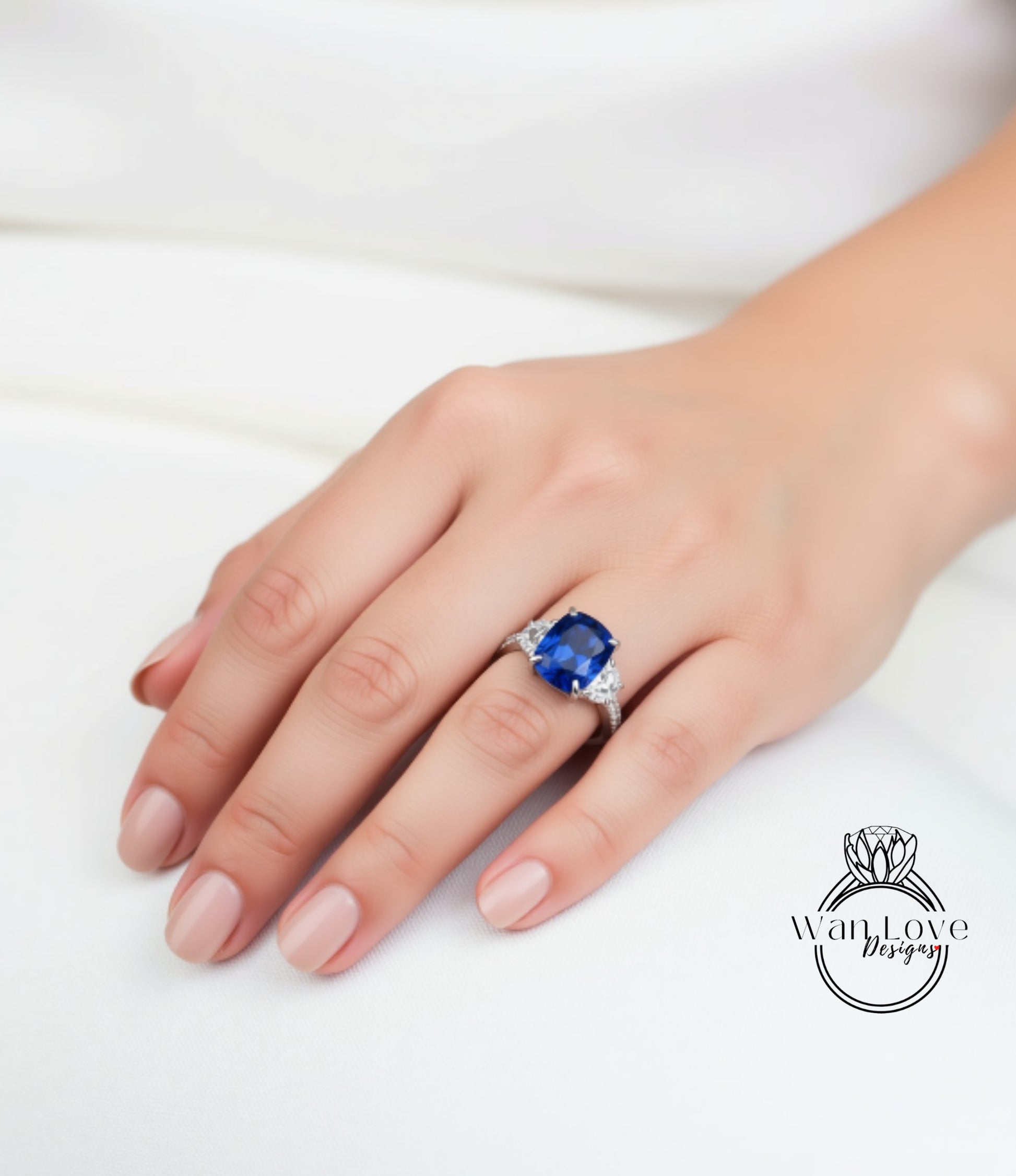 A close-up of a hand wearing a ring with a large blue gemstone.